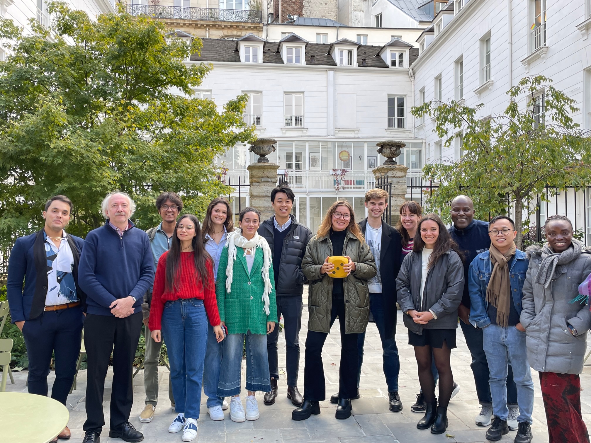 Students standing in the Reid Hall garden with Pr Boutron and Pr Clarke